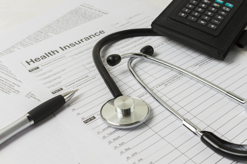 Health insurance documents, stethoscope, and calculator on desk representing Medicare eligibility in Maryland.